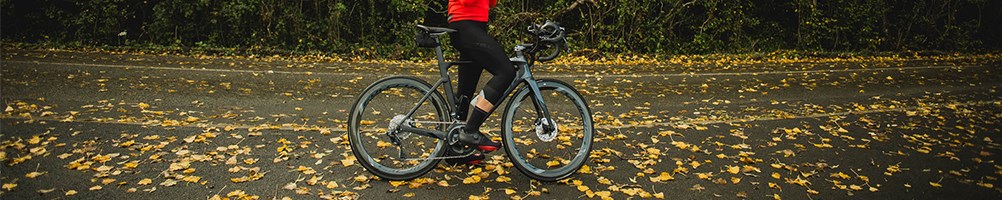 Road rider stood on the road with leaves around wearing red castelli jersey